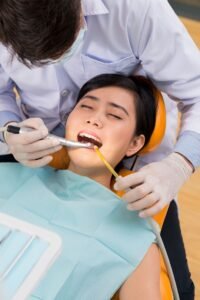 Pasien yang tampak khawatir saat berkonsultasi dengan dokter gigi di ruangan klinik pondok gigi modern