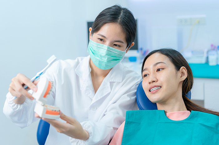 dokter gigi sedang memeriksa gigi pasien secara rutin